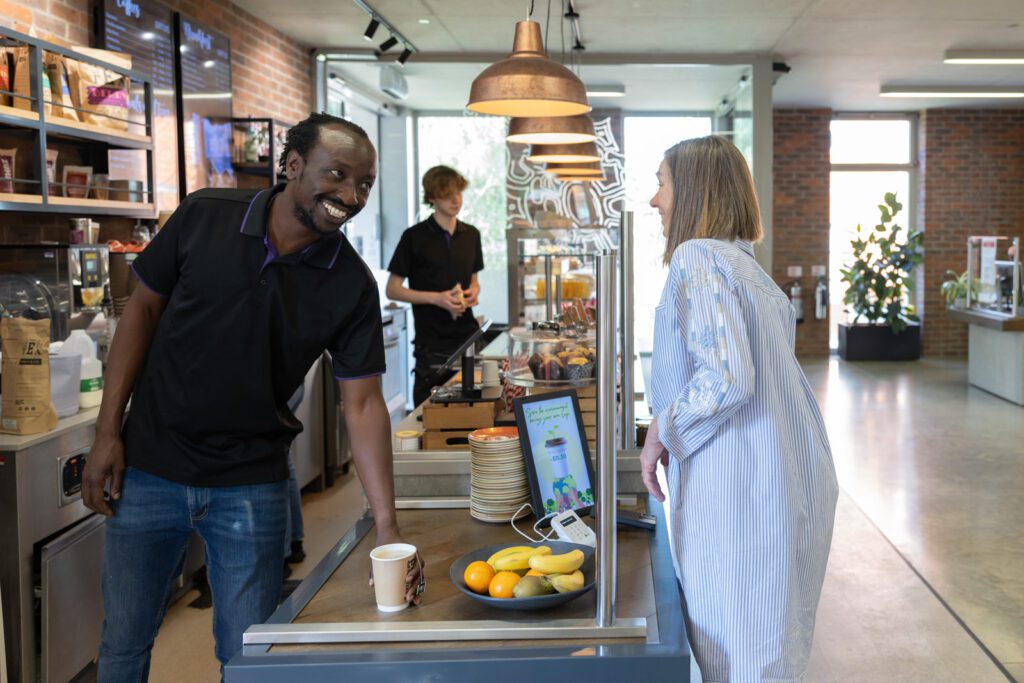 A man in the cafe, serving a customer