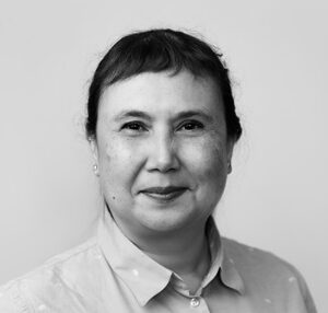 Portrait of Lisa, a woman standing in front of a plain background