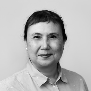 Portrait of Lisa, a woman standing in front of a plain background