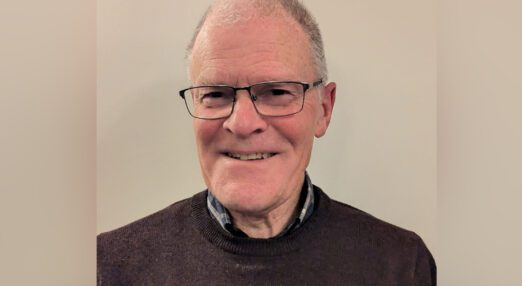 Portrait of an older man, Pat, wearing glasses and smiling