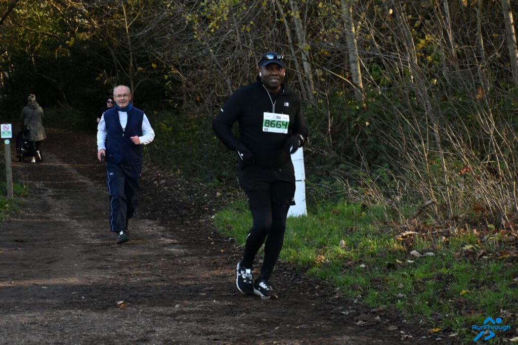 A man running a race in a woodland setting