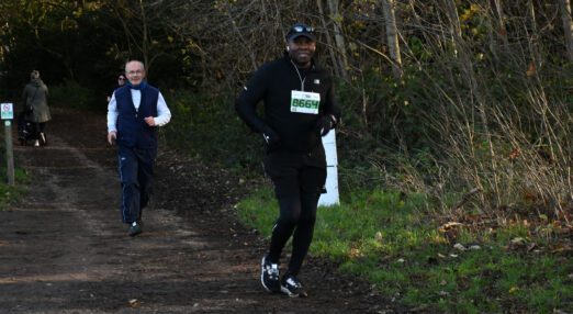 A man running a race in a woodland setting