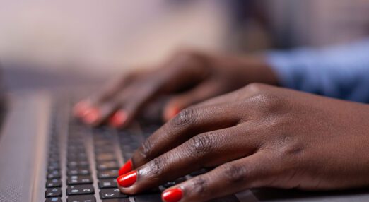 A pair of hands resting on a laptop keyboard