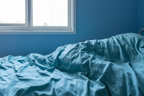 A duvet shown, on top of a bed. There is a shape under the duvet which suggests a child may be there